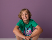 boy sitting on skateboard purple backdrop Kingston children photographer