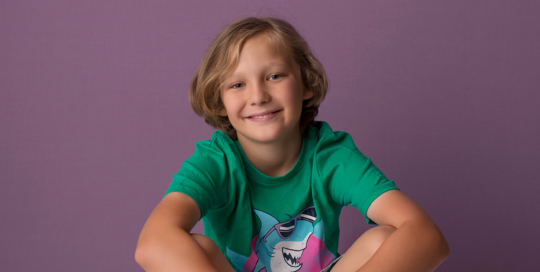 boy sitting on skateboard purple backdrop Kingston children photographer