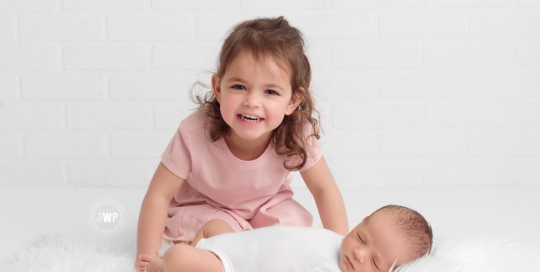 newborn boy big sister white brick Kingston portrait studio