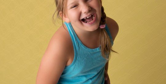 yellow backdrop girl laughing Kingston children photographer