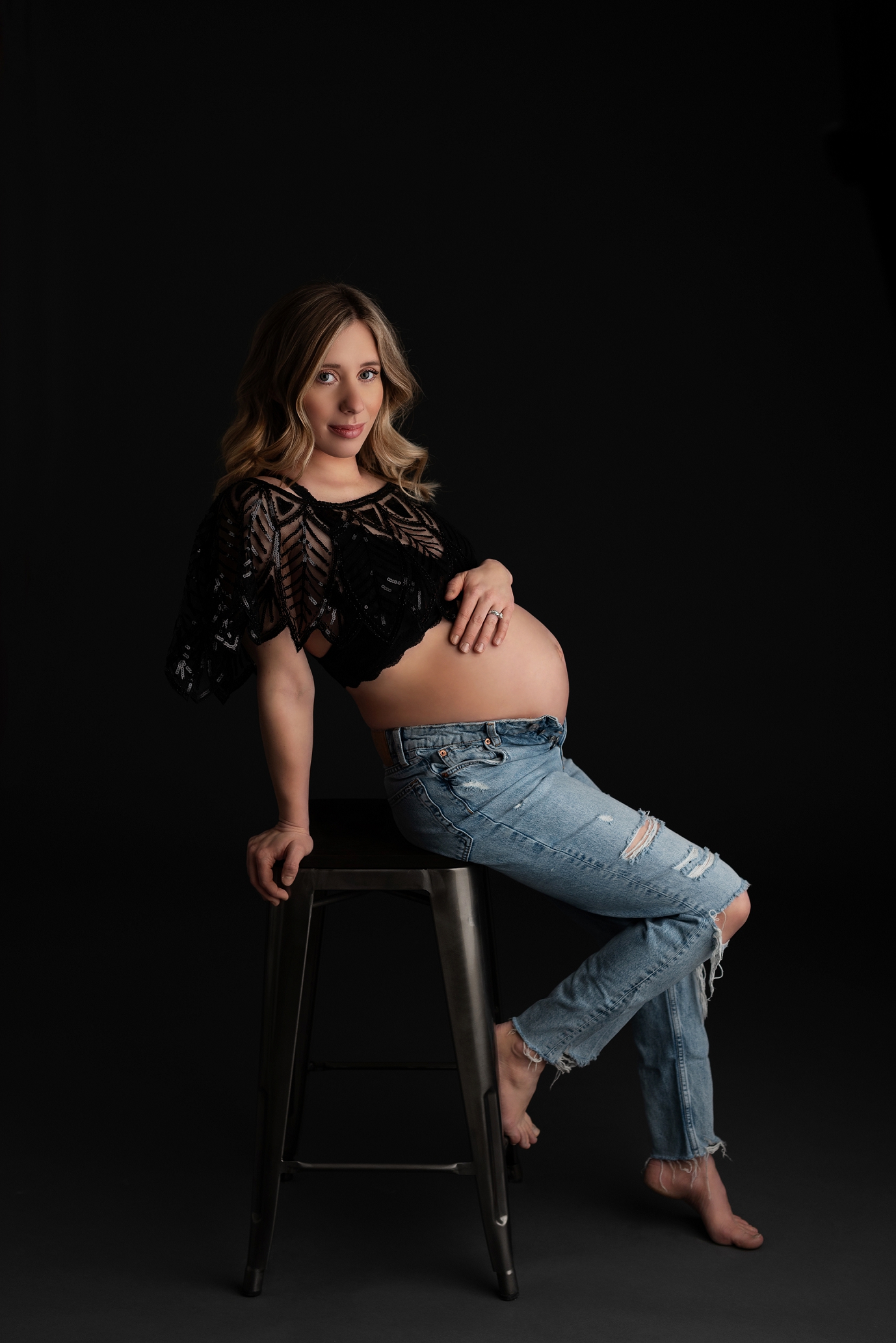 black jewel shawl on pregnant mother in jeans leaning on stool